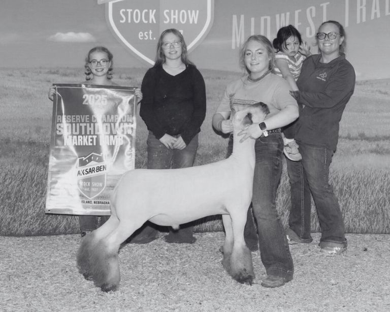 Exhibitor and family posing with a Southdown market lamb and its 2025 Ak-Sar-Ben Stock Show reserve champion banner
